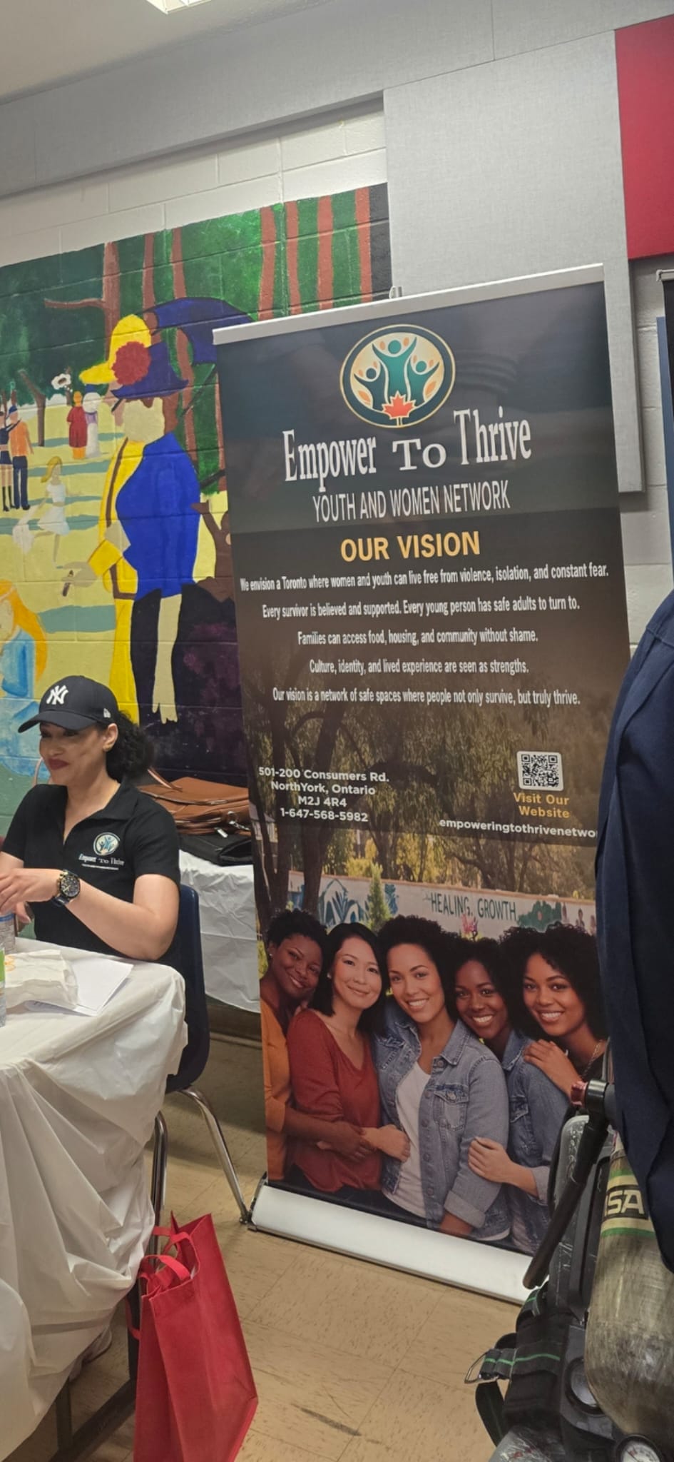 Community outreach table with official Empower To Thrive banner and contact info
