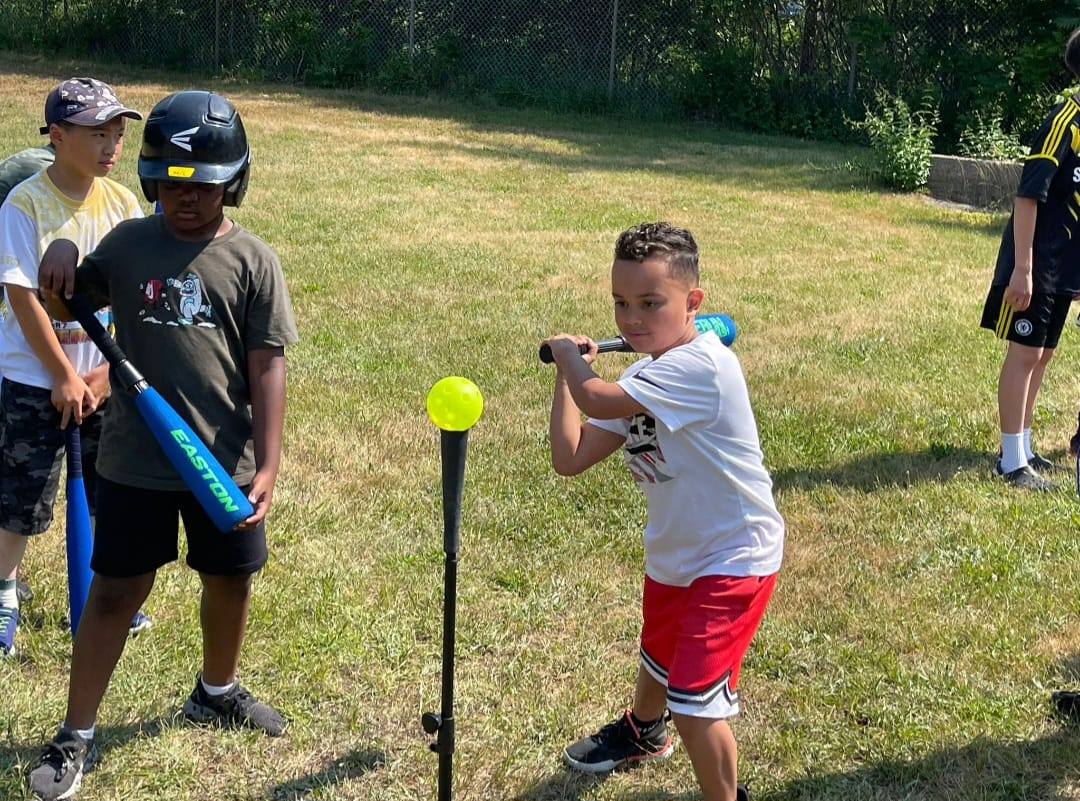 Boy swinging baseball bat with determination and joy