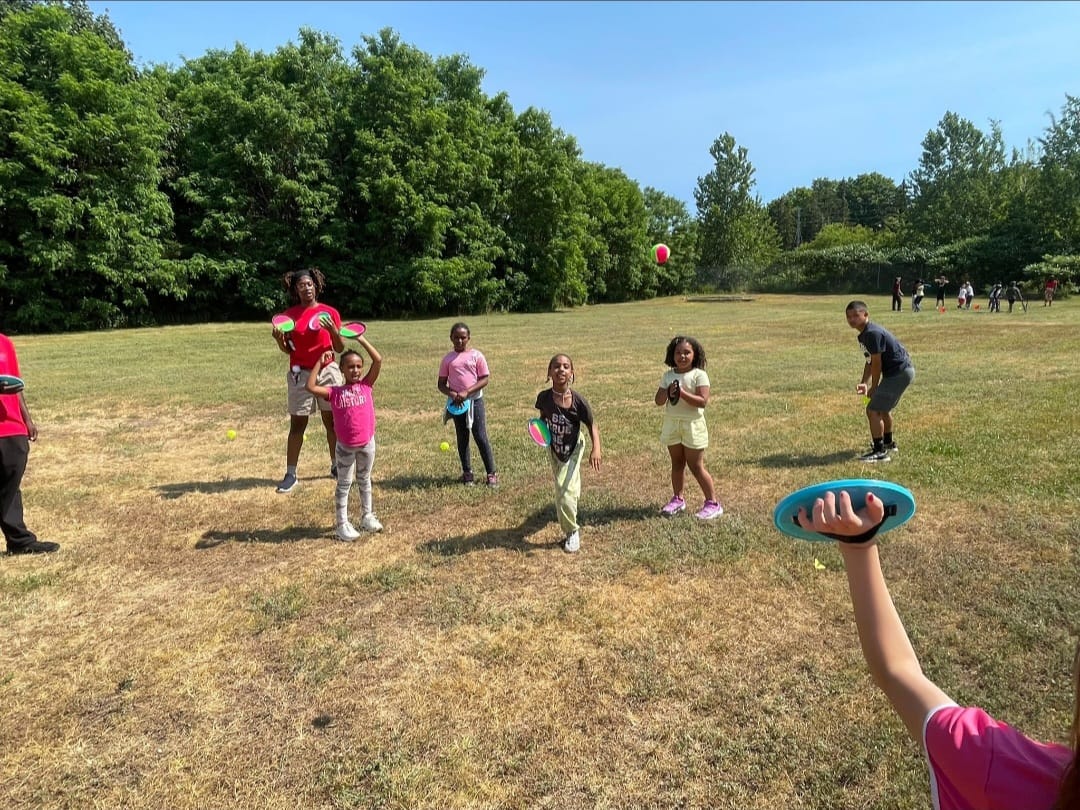 Coach and youth catching discs on the grass