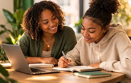 Mentor and youth studying together with a laptop, representing supportive youth mentorship and guidance.